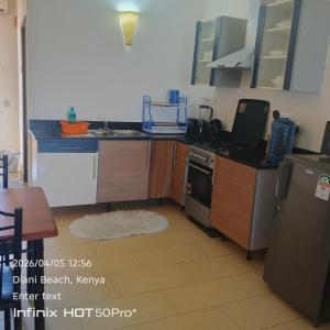 a kitchen with a sink and a stove top oven at Diani dreams Villa in Ukunda +8 photos