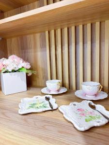 a table with three plates and bowls and spoons at Hoom Villa Thành Nội - Villa 3 phòng ngủ in Thôn An Hòa