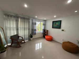 a living room with a chair and a window at Hoom Villa Thành Nội - Villa 3 phòng ngủ in Thôn An Hòa
