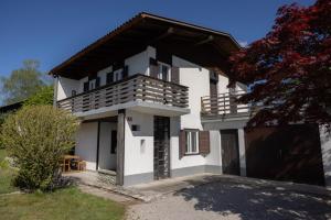 a white house with a balcony on top of it at Cosy Vintage House Bled in Bled