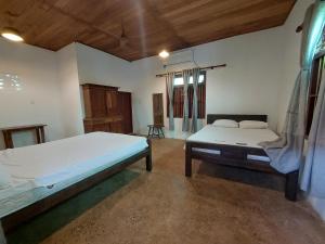 a bedroom with a large bed and a wooden ceiling at Karisal Resort & Park in Jaffna