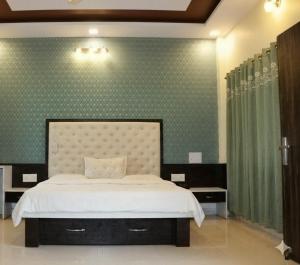 a bedroom with a bed and a green wall at Shivlok Homestay in Ujjain