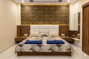 a bedroom with a large bed with blue pillows at Shivlok Homestay in Ujjain