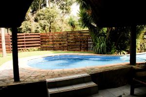 a swimming pool in a yard with a fence at Arendskop in Pretoria