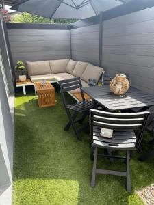 a patio with a table and chairs on grass at Superbe cocon chic, clim et terrasse privée, déco soignée in Nevers