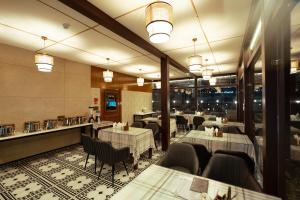 a dining room with tables and chairs and windows at Walnut Village Resort in Pahalgām