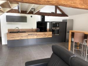 a living room with a couch and a kitchen at La Fraternelle in Ceyzérieu