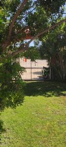 a fence in front of a house with a yard at Hotel La Corte Rosada in Villasimius