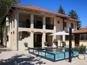 a house with a swimming pool and an umbrella at Mirage Apartments & Pool - Balatonboglar in Balatonboglár