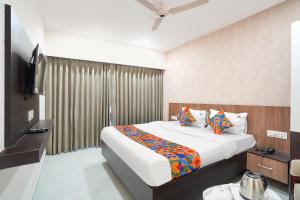 a hotel room with a bed and a television at FabHotel Sahyadri Mantram in Pune +29 photos