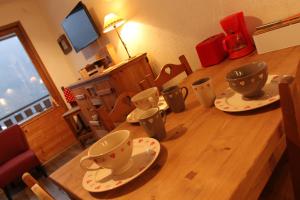 a wooden table with two cups and saucers on it at Appartement Chatel Centre in Châtel