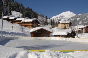 a parking lot covered in snow in front of a building at Appartement Chatel Centre in Châtel