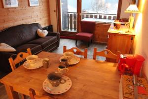 a living room with a wooden table with cups on it at Appartement Chatel Centre in Châtel