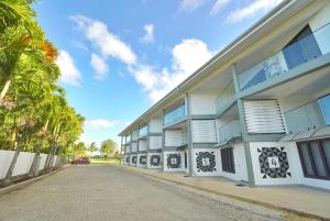 a building with palm trees next to a street at Lagoon Apartments in Nuku‘alofa