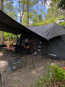 a black tent with a table and chairs in it at Pakis Camping Cikole in Tangkubanperahu