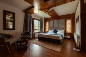 a bedroom with a bed and a desk and a chair at Walnut Village Resort in Pahalgām +19 photos