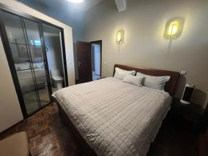 a bedroom with a large bed with white sheets and pillows at Le felix in Antananarivo