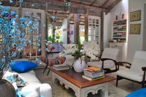 a living room with a table with books and flowers at Pousada Canto do Camburi in Camburi