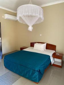a bedroom with a large bed with a blue blanket at Wayekha Hotels in Kasungu