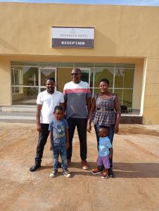 a group of people standing in front of a building at Wayekha Hotels in Kasungu