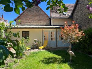 a house with a garden and a bird in the yard at MAISON privée, La glycine blanche, a 10min de Strasbourg in Schiltigheim