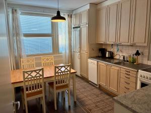 a kitchen with white cabinets and a table and chairs at Huoneisto Vipunen in Savonlinna