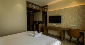 a hotel room with a bed and a television at Hotel Rio in Siliguri