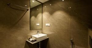 a bathroom with a sink and a mirror at Hotel Rio in Siliguri