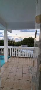 a balcony with a view of a pool and a fence at Résidence Aiko CÔTIERS in Mahébourg