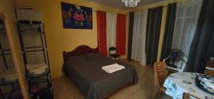 a small bedroom with a bed and a table at Résidence Aiko CÔTIERS in Mahébourg