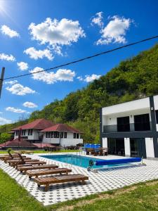 a swimming pool with benches and a building at Forest View Villa in Ilijaš