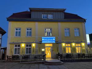 a yellow building with a blue sign on it at HELENA Hotel & Restaurant in Mirow