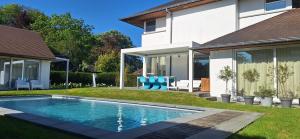 a swimming pool in a yard next to a house at Guesthouse Thibault in Gistel