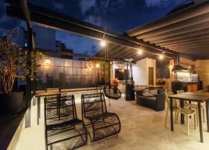 a patio with chairs and a table and a couch at Ceci House - Santa Cecília in São Paulo