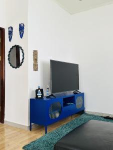 a blue entertainment center with a flat screen tv on it at Villa Almadies in Pointe-Noire