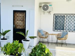 a patio with chairs and plants in front of a door at Villa Almadies in Pointe-Noire
