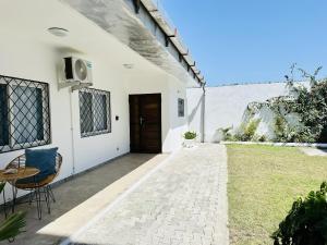 a white house with a door and a table and chairs at Villa Almadies in Pointe-Noire