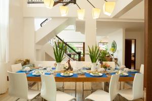 a dining room with a table and white chairs at Balay Pahuwai Bed & Breakfast in Tagaytay