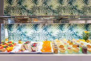eine Vitrine mit vielen verschiedenen Dessertsorten in der Unterkunft Hotel Golden in Benidorm