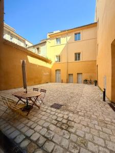 an empty courtyard with a table and a building at T2 monument historique Aix en provence in Aix-en-Provence
