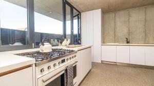 a kitchen with a stove and some windows at Mi Amor Beach House in Sedgefield +36 photos