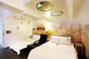 a hotel room with two beds and a mirror at Amant Hotel in Goyang
