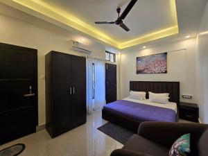 a bedroom with a purple bed and a couch at Lir-etso Homestay in Diphu