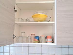 a cupboard with a bowl and other kitchen items at Tolle Economy Stay in Padova +67 photos