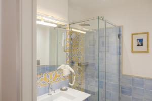 a bathroom with a sink and a glass shower at Spighe e Fenicotteri in Modica