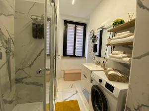 a bathroom with a shower and a washing machine at Leo&Franci Loft in Legnano