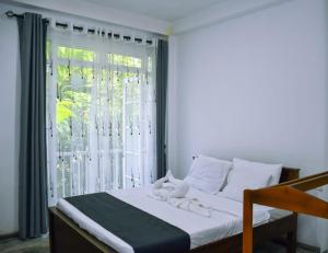 a bedroom with a bed and a large window at Eco Bless Inn in Kandy