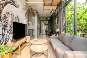 a living room with a couch and a tv at Ombra House No. 21-24 in Chiang Mai
