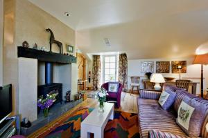 a living room with a couch and a fireplace at The Dick Turpin Cottage in Clun