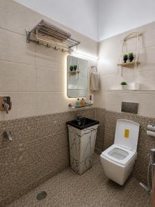 a bathroom with a toilet and a sink and a mirror at Hidden Leaf in Dehradun +56 photos